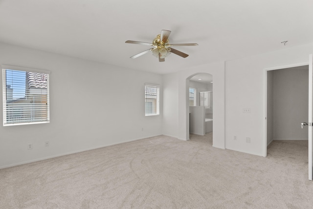 4349 Bethpage Dr, Palmdale, CA 93551 - unfurnished bedroom with arched walkways, multiple windows, light carpet, and baseboards