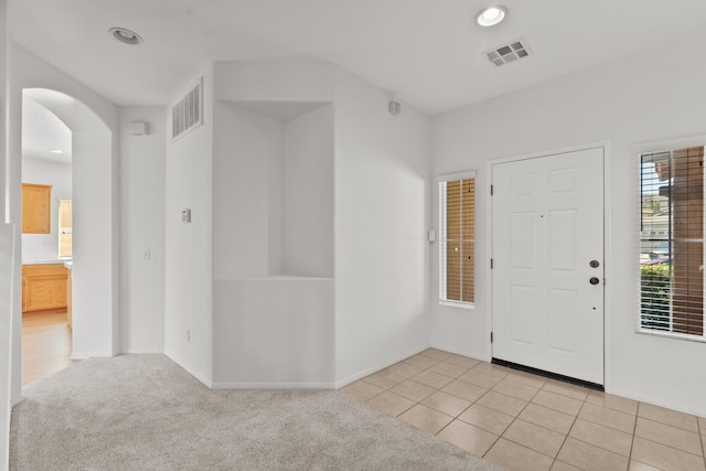 4349 Bethpage Dr, Palmdale, CA 93551 - foyer entrance featuring arched walkways, recessed lighting, light tile patterned floors, baseboards, and light colored carpet