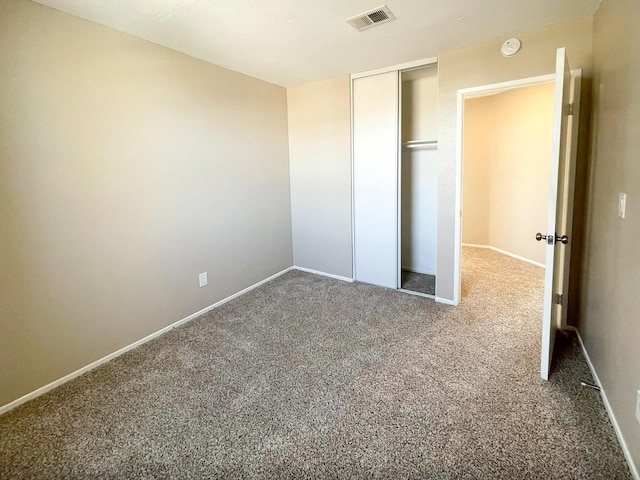 unfurnished bedroom featuring a closet, visible vents, carpet flooring, and baseboards