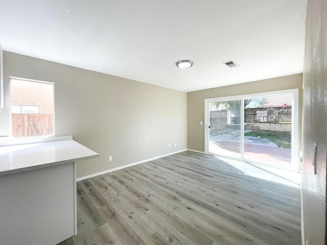 unfurnished room featuring visible vents, baseboards, and wood finished floors