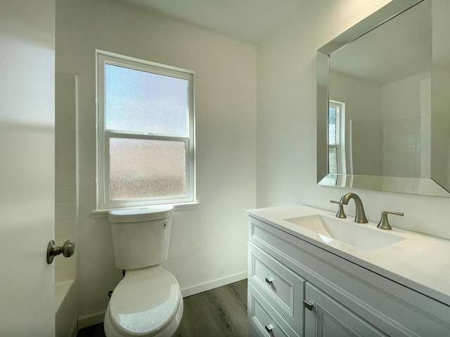 bathroom featuring baseboards, plenty of natural light, wood finished floors, and vanity