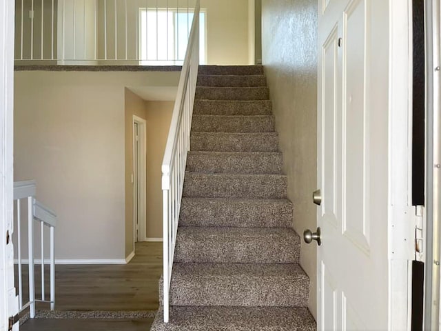 stairway with baseboards and wood finished floors