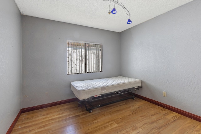 bedroom featuring light hardwood / wood-style flooring and a textured ceiling