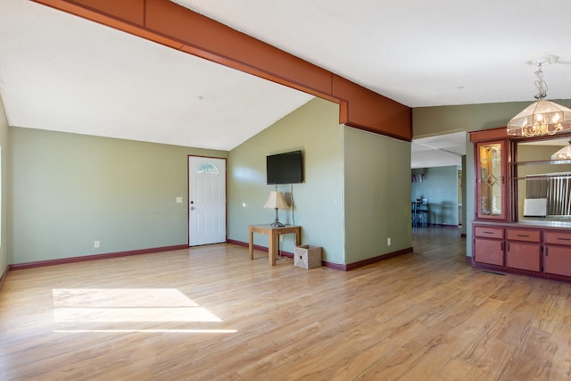 living room featuring lofted ceiling, a chandelier, and light hardwood / wood-style floors