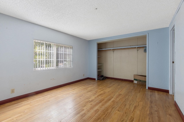 unfurnished bedroom featuring light hardwood / wood-style flooring, a closet, and a textured ceiling