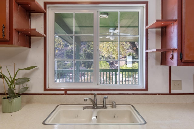 kitchen with ceiling fan, sink, and wall chimney range hood