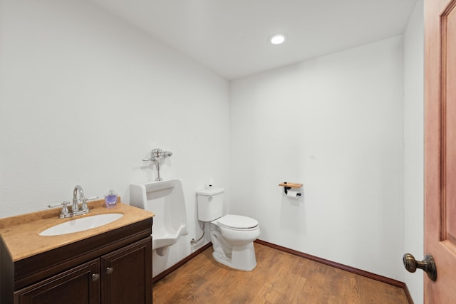 bathroom with baseboards, vanity, toilet, and wood finished floors