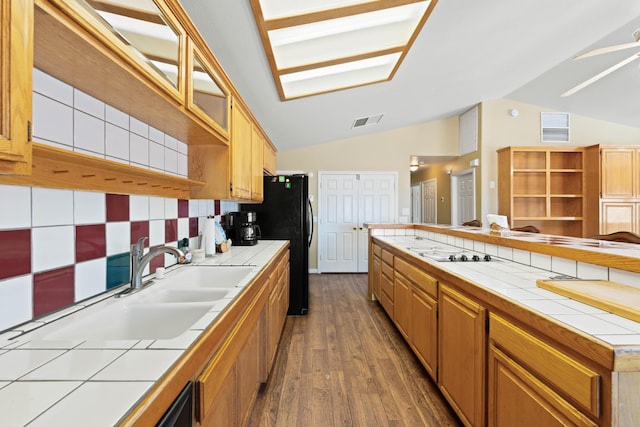 kitchen featuring visible vents, vaulted ceiling, and tile countertops