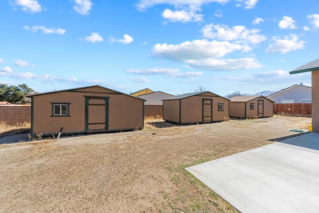 view of yard featuring a shed, a fenced backyard, and an outdoor structure