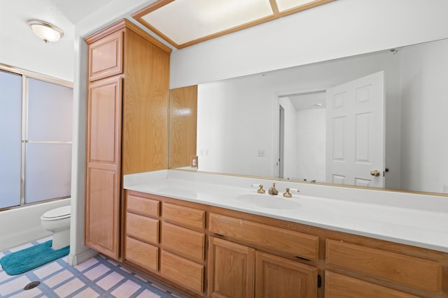 full bathroom featuring bath / shower combo with glass door, vanity, and toilet