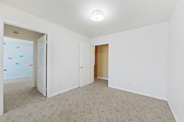 unfurnished bedroom with carpet floors and baseboards