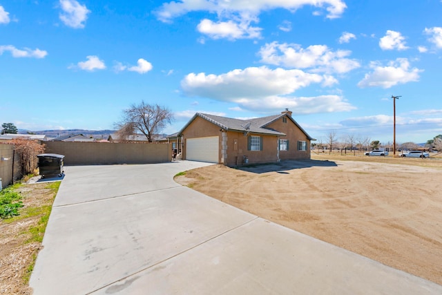 view of front facade with driveway, an attached garage, fence, and stucco siding