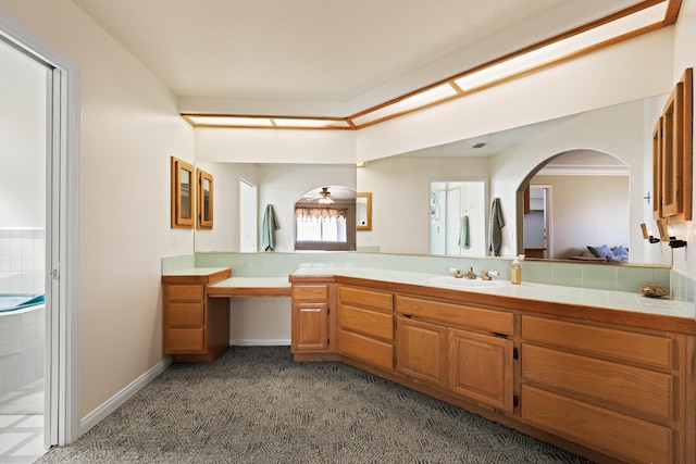 bathroom featuring baseboards, carpet flooring, and vanity