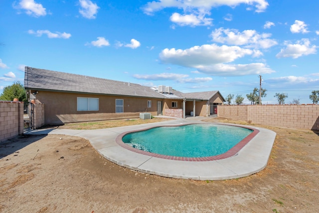 view of swimming pool featuring a fenced backyard, a fenced in pool, central AC, and a patio