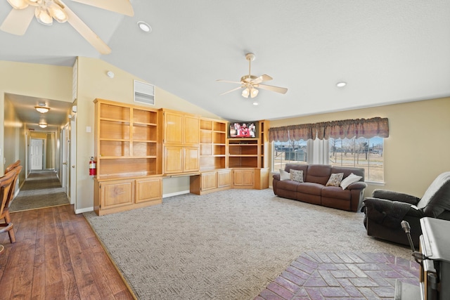 living room featuring lofted ceiling, built in study area, ceiling fan, and visible vents