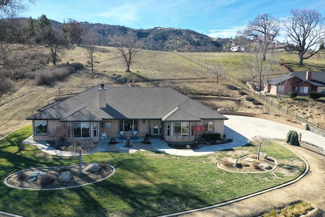 exterior space with a mountain view, a lawn, and a patio