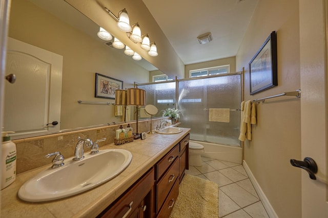 full bathroom with tasteful backsplash, shower / bath combination with glass door, tile patterned flooring, vanity, and toilet