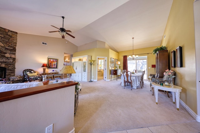 interior space featuring high vaulted ceiling, decorative light fixtures, ceiling fan with notable chandelier, and light carpet