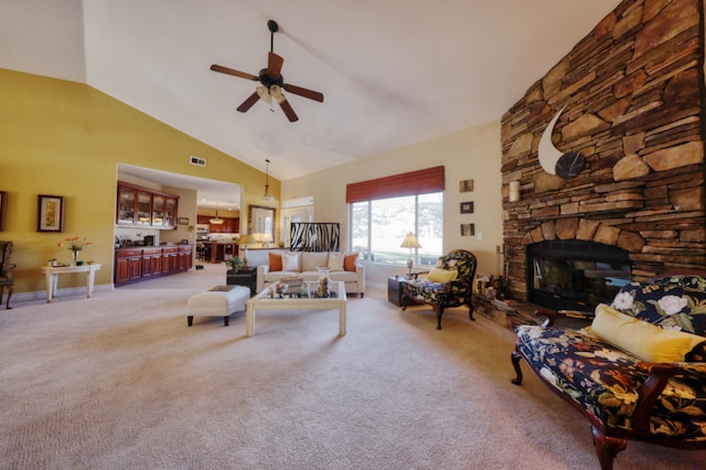 carpeted living room featuring ceiling fan, a stone fireplace, and high vaulted ceiling