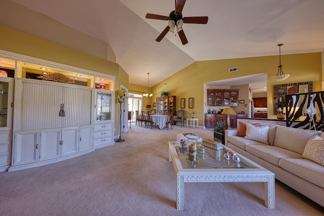 carpeted living room with ceiling fan and vaulted ceiling