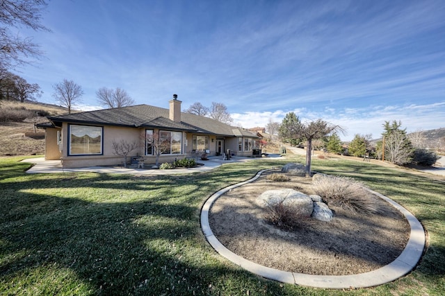 back of property featuring a patio and a lawn