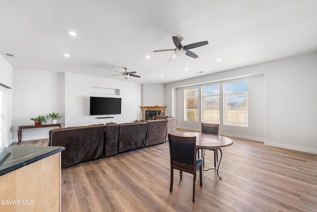 42094 W 21st St, Lancaster, CA 93536 - living room with a warm lit fireplace, light wood-style flooring, a ceiling fan, and recessed lighting