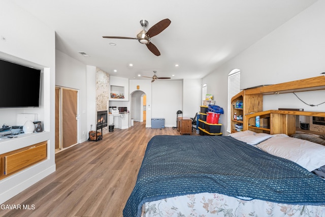 42094 W 21st St, Lancaster, CA 93536 - bedroom featuring arched walkways, light wood-type flooring, a large fireplace, and recessed lighting