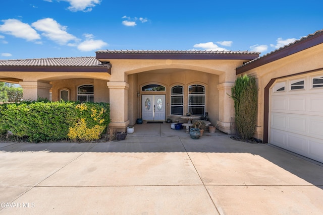 42094 W 21st St, Lancaster, CA 93536 - view of exterior entry with stucco siding, an attached garage, driveway, and a tile roof