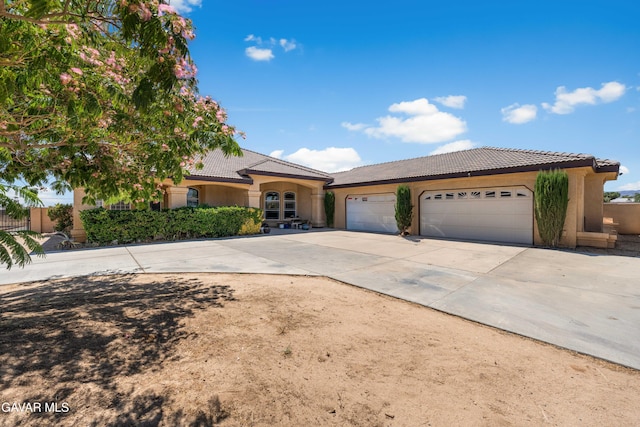 42094 W 21st St, Lancaster, CA 93536 - mediterranean / spanish house featuring a tile roof, stucco siding, driveway, and an attached garage