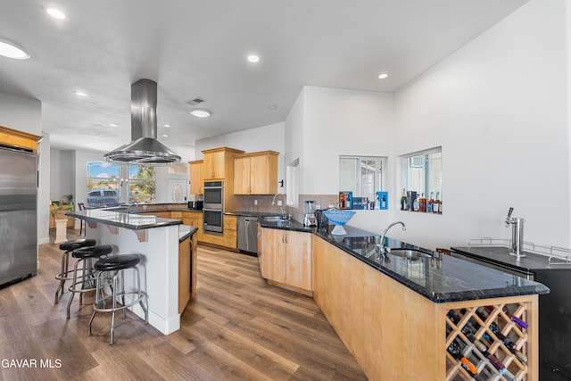 42094 W 21st St, Lancaster, CA 93536 - kitchen with stainless steel appliances, light brown cabinetry, island exhaust hood, a peninsula, and wood finished floors