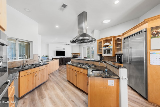 42094 W 21st St, Lancaster, CA 93536 - kitchen with built in appliances, wall chimney exhaust hood, decorative backsplash, light wood finished floors, and glass insert cabinets
