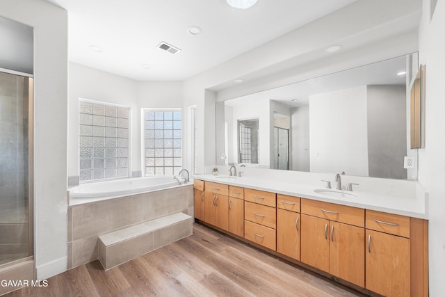 42094 W 21st St, Lancaster, CA 93536 - full bathroom featuring a garden tub, wood finished floors, double vanity, a stall shower, and recessed lighting