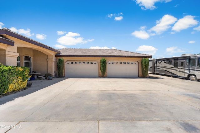 42094 W 21st St, Lancaster, CA 93536 - view of front of property with stucco siding, a tiled roof, driveway, and a garage