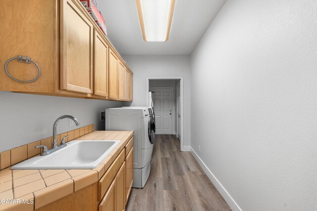 42094 W 21st St, Lancaster, CA 93536 - laundry area with light wood-style floors, washer / dryer, and cabinet space