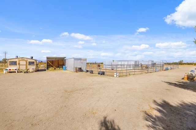 view of yard with a rural view and an outdoor structure