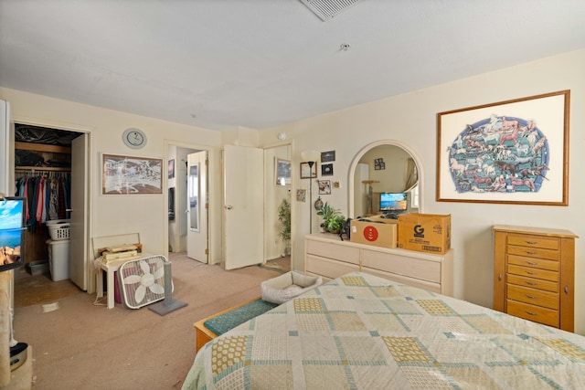 carpeted bedroom with a walk in closet and a closet