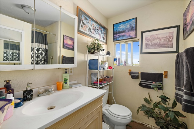 bathroom with walk in shower, vanity, and toilet