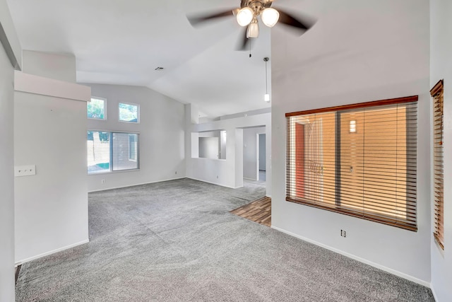 unfurnished living room featuring carpet floors, vaulted ceiling, and ceiling fan