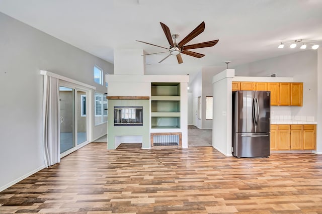 kitchen with built in features, light hardwood / wood-style floors, stainless steel refrigerator, and ceiling fan