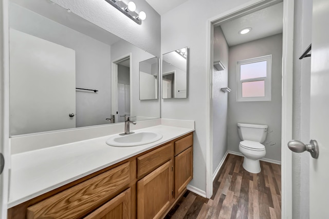 bathroom featuring hardwood / wood-style floors, vanity, and toilet