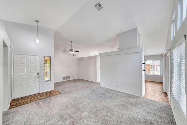 foyer featuring ceiling fan, carpet, and high vaulted ceiling