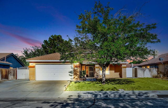 single story home featuring a lawn and a garage