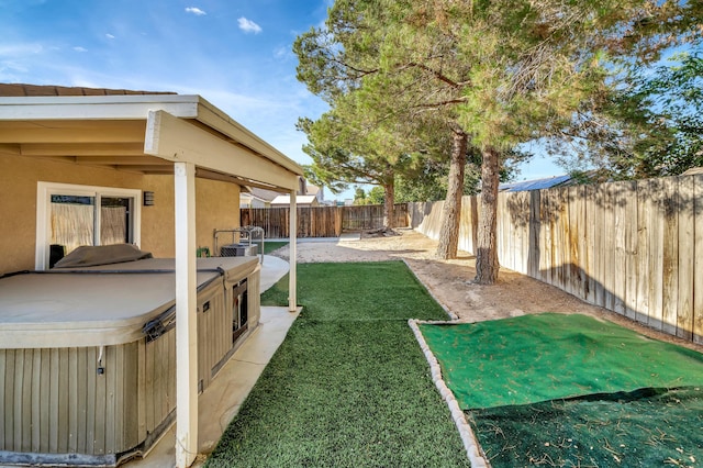 view of yard with a patio area and a hot tub