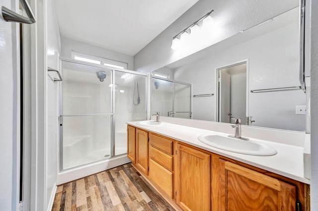 bathroom with vanity, wood-type flooring, and an enclosed shower