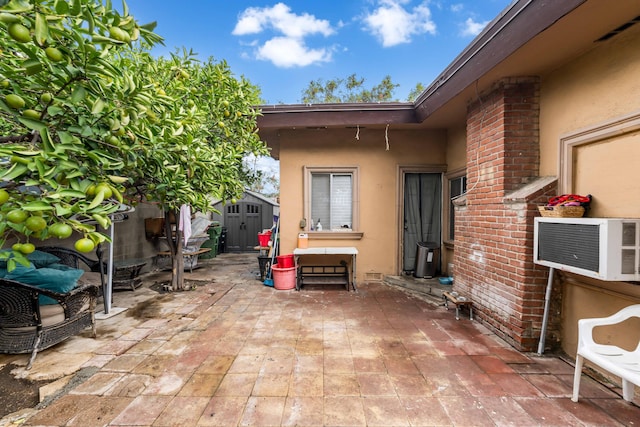 view of patio with a storage unit and cooling unit