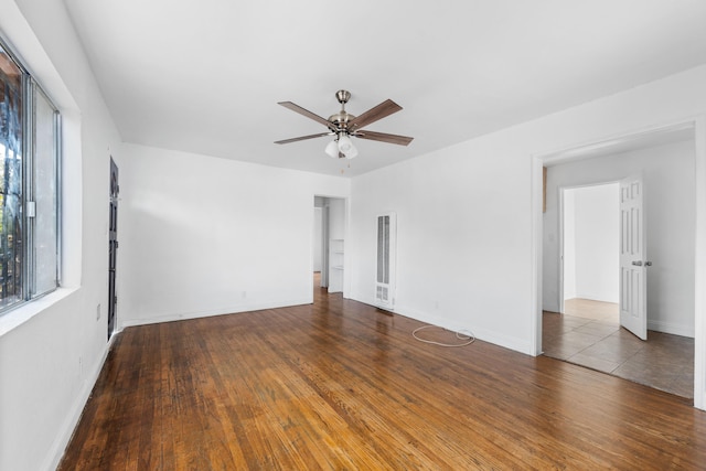 spare room featuring ceiling fan and dark wood-type flooring