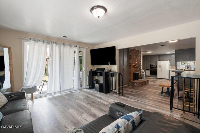 43818 Halcom Ave, Lancaster, CA 93536 - living room with plenty of natural light, light wood finished floors, and a fireplace