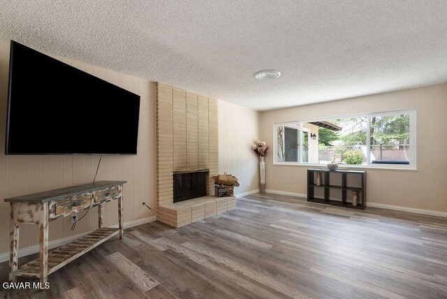 43818 Halcom Ave, Lancaster, CA 93536 - living area featuring a textured ceiling, wood finished floors, and a brick fireplace