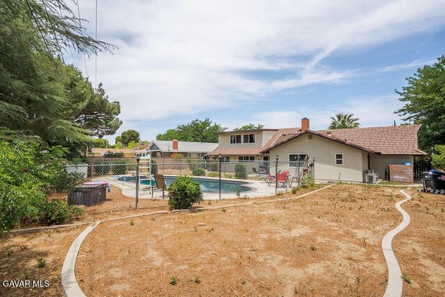 43818 Halcom Ave, Lancaster, CA 93536 - back of house with a chimney, stucco siding, and a tile roof