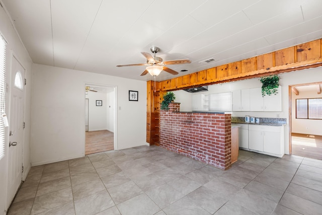 kitchen with ceiling fan and white cabinetry